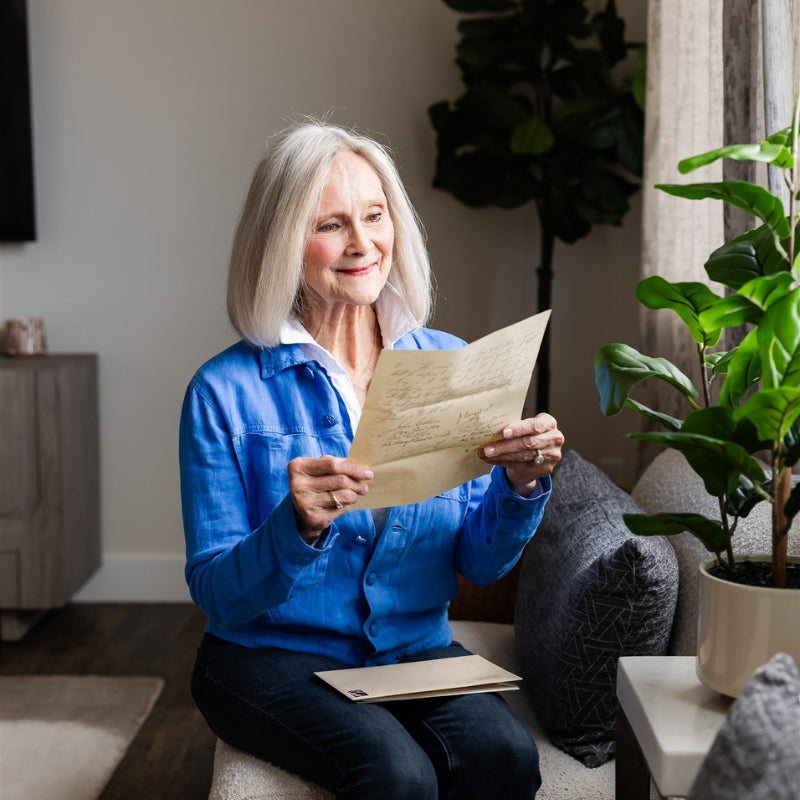 A woman holding a History By Mail document replica