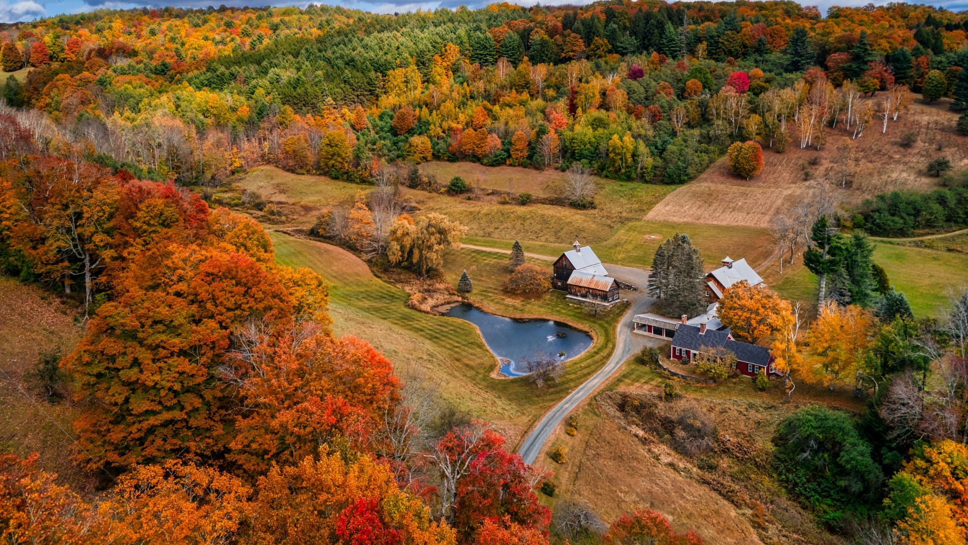 A barn nestled in a valley during fall in Vermont. - History By Mail
